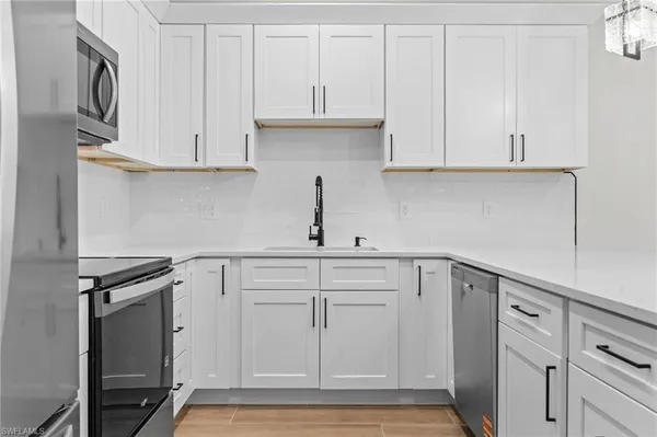 a kitchen with white cabinets and a sink
