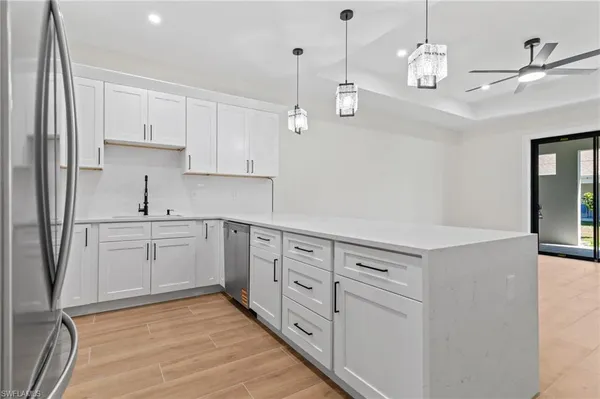 a kitchen with white cabinets and white appliances