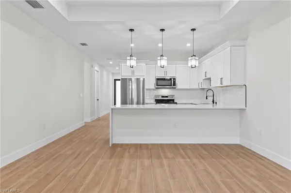 a view of kitchen with kitchen island sink stainless steel appliances and cabinets