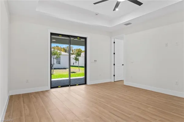 an empty room with floor to ceiling window and an outdoor view