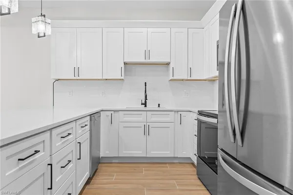 a kitchen with white cabinets and white appliances