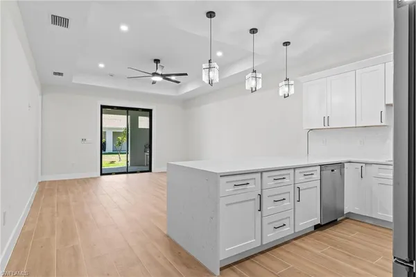 a view of an empty room with window and wooden floor