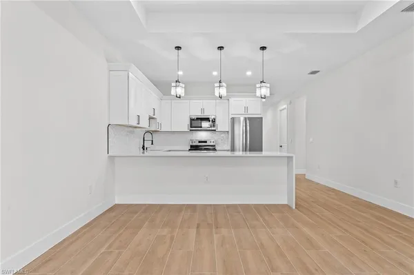 a view of kitchen and hall with wooden floor