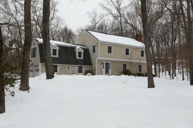 a front view of a house with a yard covered in snow