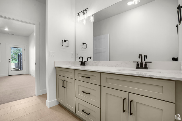 1631 West Century Lane, Unit C Mapleton, UT 84664 - Photo 20 of 31 Dual vanity featuring light-toned cabinetry with matte black hardware, integrated sinks, and a stone-finish countertop