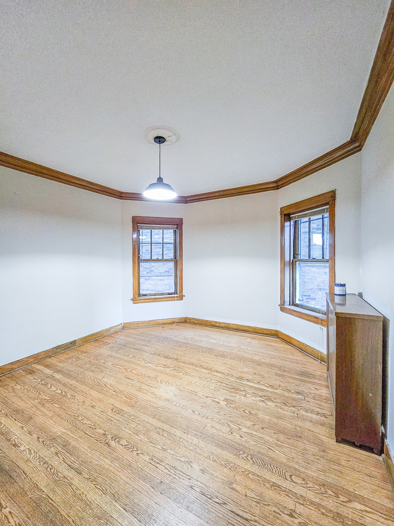 3338 West Cullom Avenue, Unit 1 Chicago, IL 60618 - Photo 6 of 14 a view of an empty room with wooden floor and a window