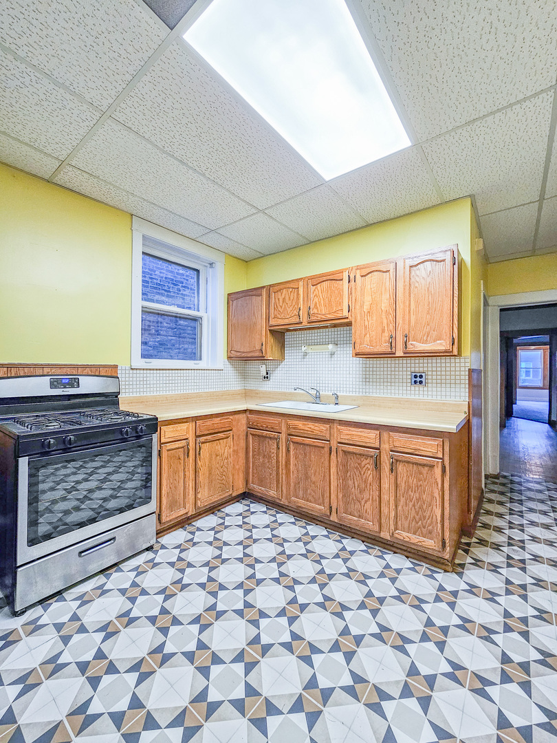 3338 West Cullom Avenue, Unit 1 Chicago, IL 60618 - Photo 8 of 14 a kitchen with stainless steel appliances wooden cabinets and a sink