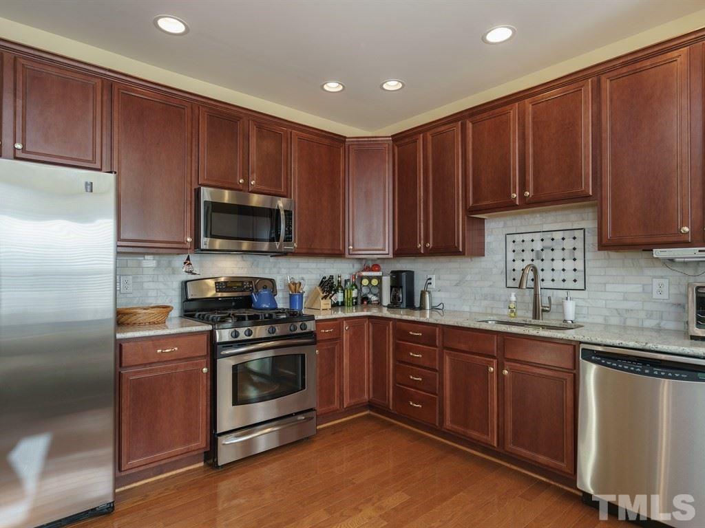 9523 Vira Drive Raleigh, NC 27617 - Photo 11 of 25 a kitchen with wooden cabinets and stainless steel appliances