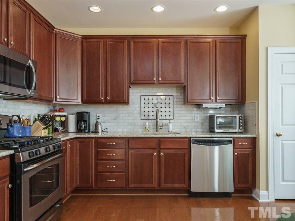 9523 Vira Drive Raleigh, NC 27617 - Photo 12 of 25 a kitchen with granite countertop wooden cabinets and stainless steel appliances