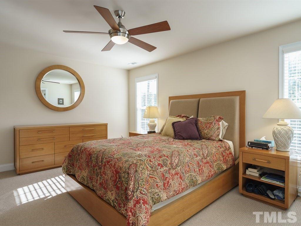 9523 Vira Drive Raleigh, NC 27617 - Photo 14 of 25 a bedroom with a bed and a chandelier