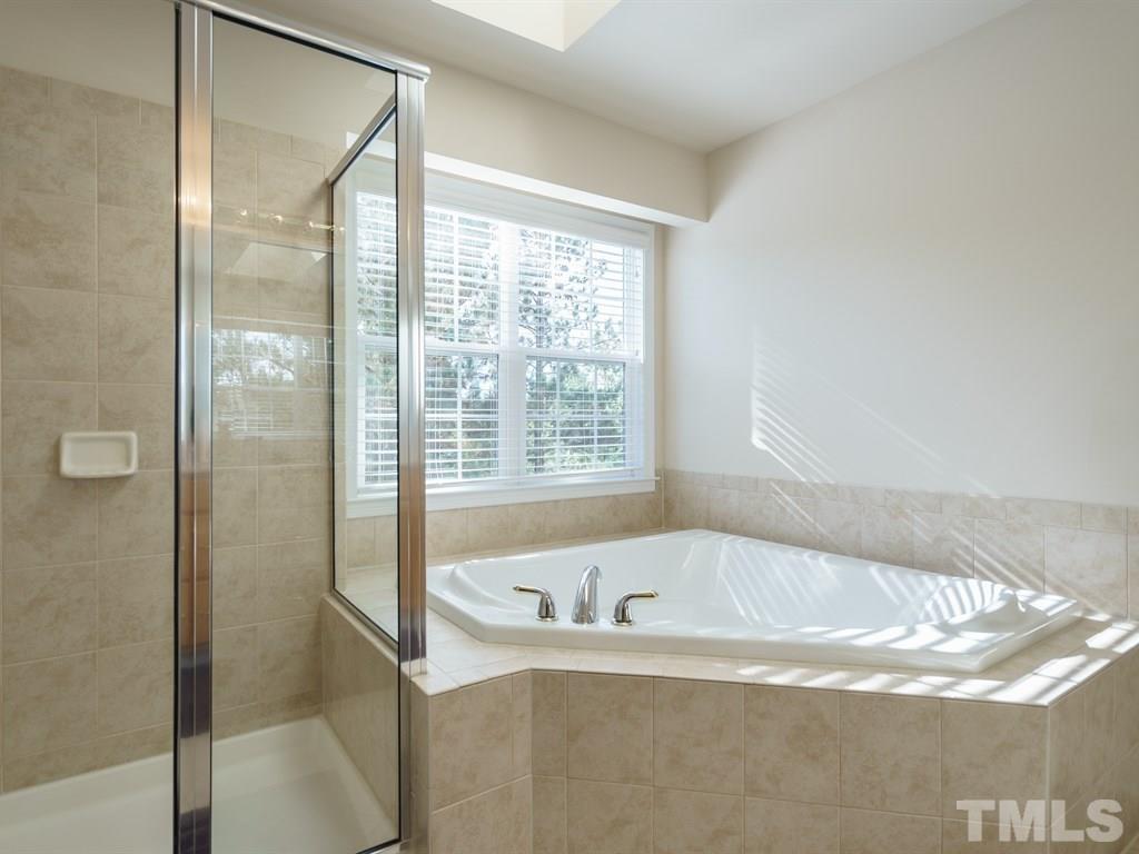 9523 Vira Drive Raleigh, NC 27617 - Photo 17 of 25 a white bath tub sitting next to a shower