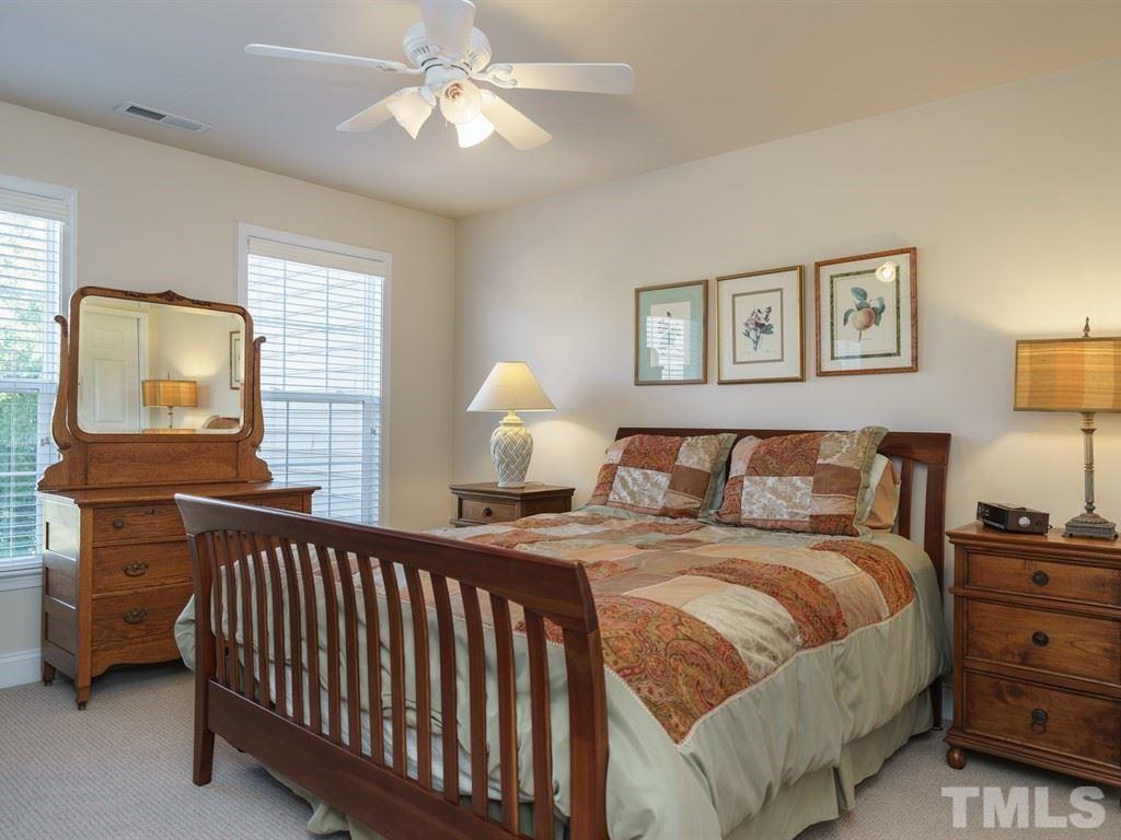 9523 Vira Drive Raleigh, NC 27617 - Photo 18 of 25 a bedroom with a bed and a chandelier