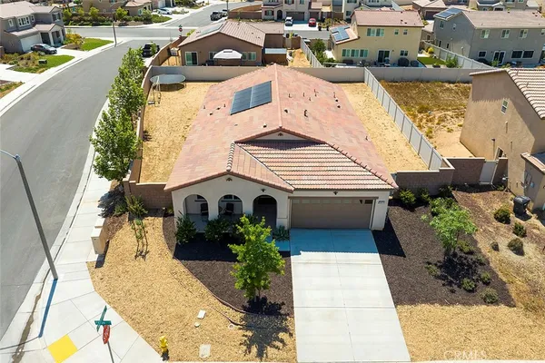 a front view of a house with a yard and potted plants