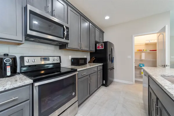 a kitchen with stainless steel appliances granite countertop a stove microwave and sink