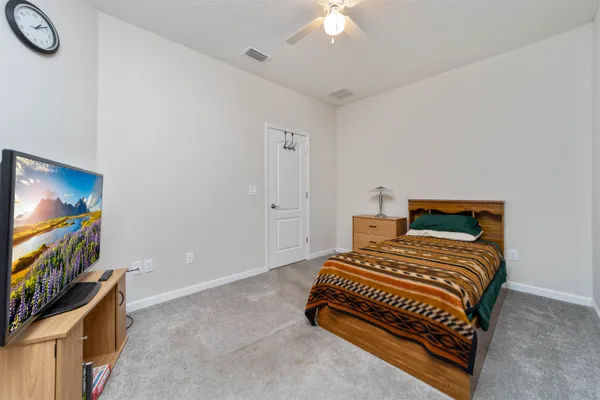 a bedroom with a bed and a flat screen tv