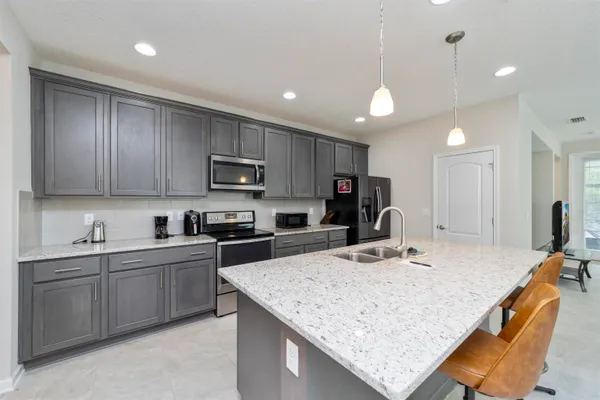 a kitchen with kitchen island a sink stove and refrigerator