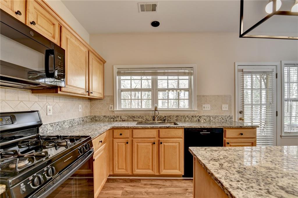 100 Hawnley Trc Northwest Suwanee, GA 30024 - Photo 26 of 58 a kitchen with stainless steel appliances granite countertop a stove a sink and a microwave