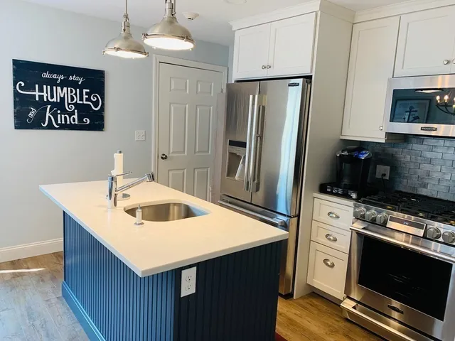 a kitchen with stainless steel appliances a stove a sink and a refrigerator