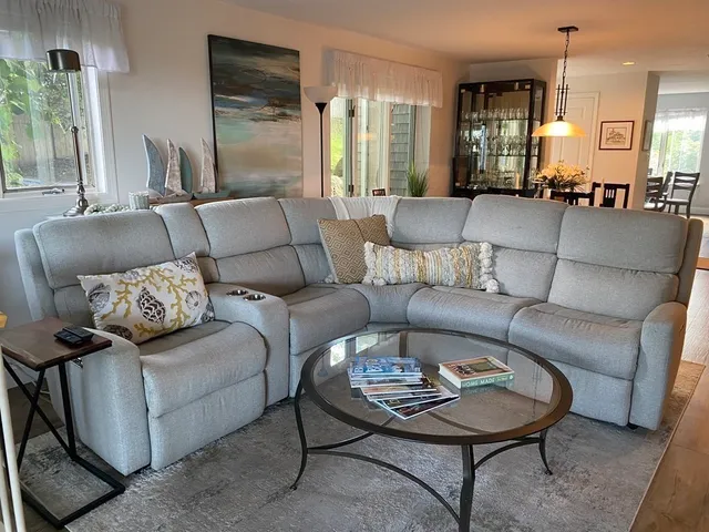a living room with furniture wooden floor and a large window