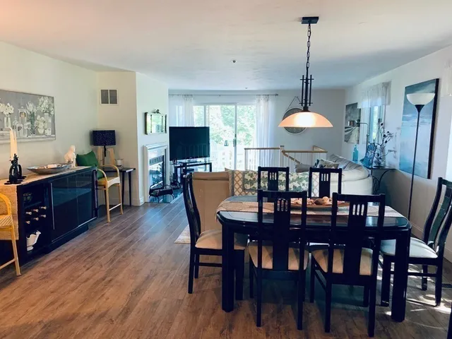 a view of a dining room with furniture a chandelier and wooden floor