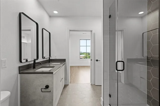 a bathroom with a granite countertop sink a mirror and shower