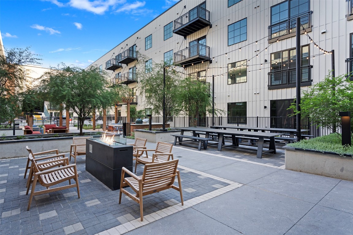 4315 South Congress Avenue, Unit 433 Austin, TX 78745 - Photo 17 of 23 a view of a patio with dining table and chairs with plants and palm trees