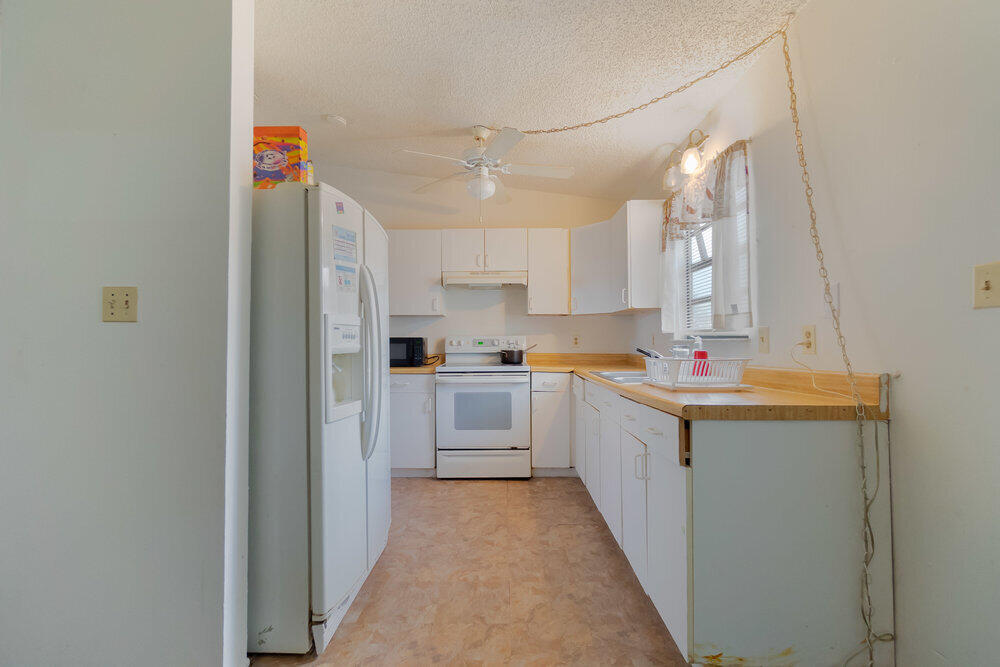 1564 West 20th Street Riviera Beach, FL 33404 - Photo 7 of 23 a kitchen with stainless steel appliances granite countertop a sink and cabinets