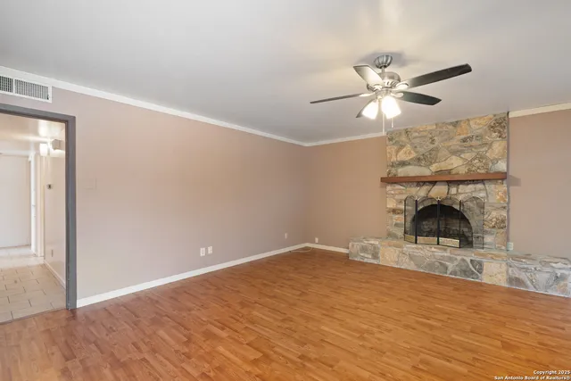 a view of empty room with fireplace and fan