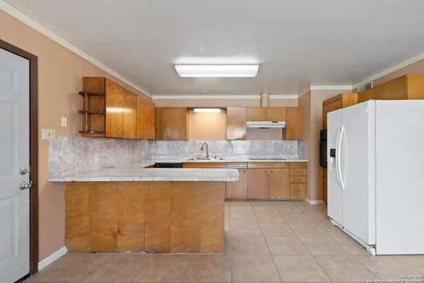 a large kitchen with a refrigerator a sink dishwasher with a dining table and chairs