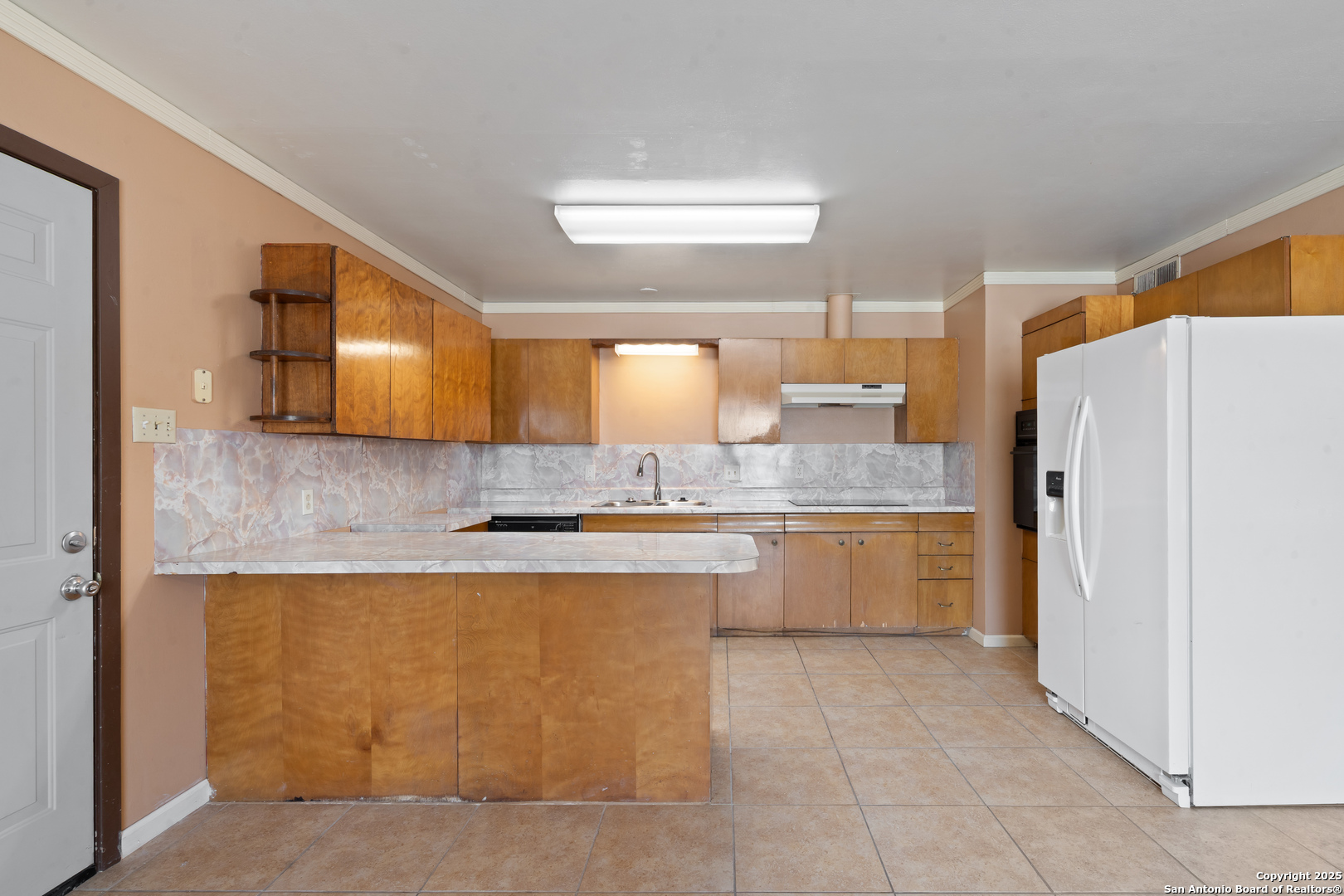 203 Margaret Lane Del Rio, TX 78840 - Photo 16 of 42 a large kitchen with a refrigerator a sink dishwasher with a dining table and chairs