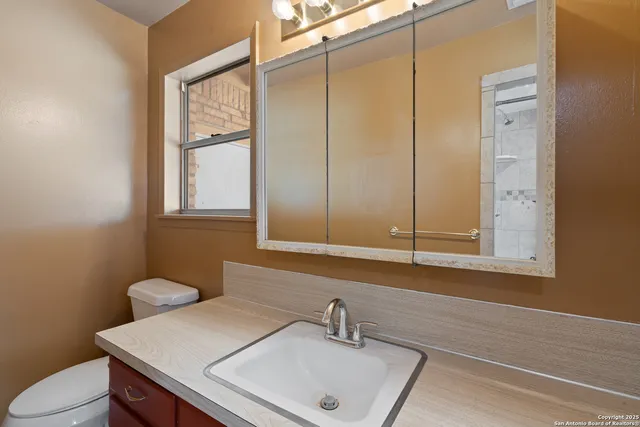 a bathroom with a sink a toilet and a mirror