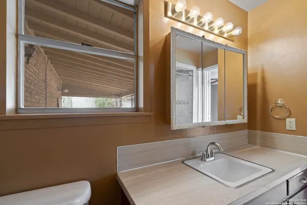 a bathroom with a sink a toilet and mirror