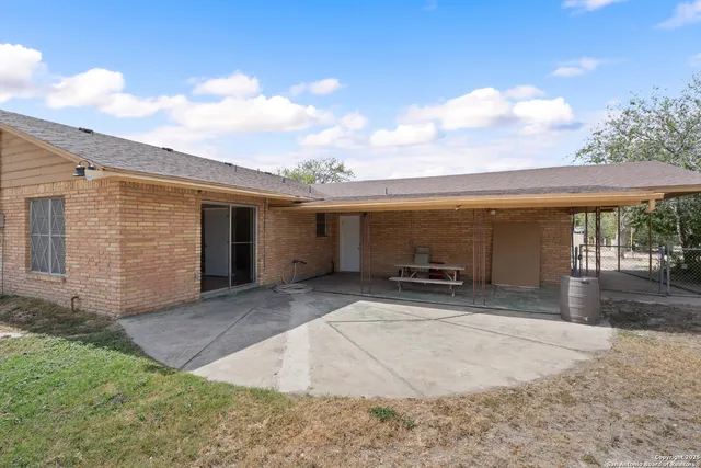 a view of a house with backyard and a tree