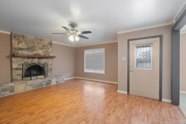 a view of empty room with fireplace and wooden floor