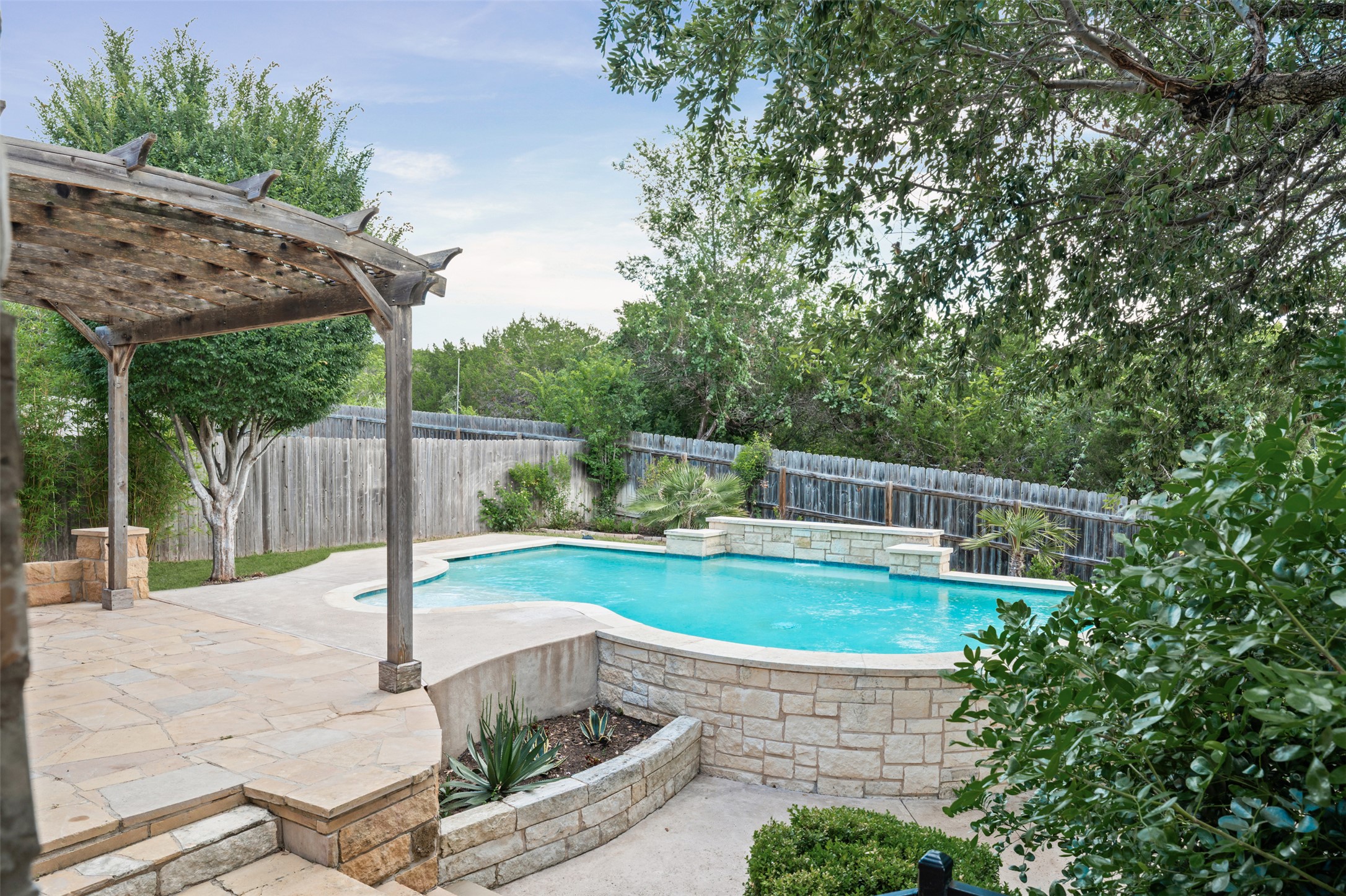 8820 Colberg Drive Austin, TX 78749 - Photo 28 of 35 An inviting pool beckons, surrounded by lush landscaping and a charming stone patio.