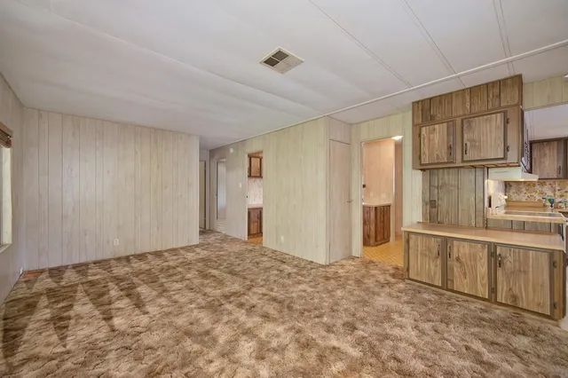 a living room with furniture a dining table and a refrigerator