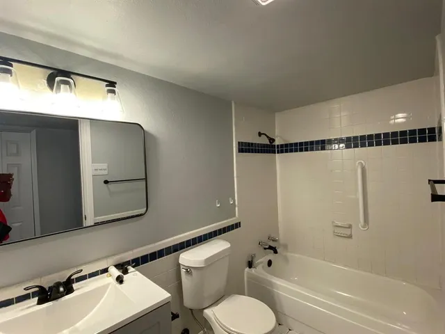 a bathroom with a bathtub shower sink vanity and toilet