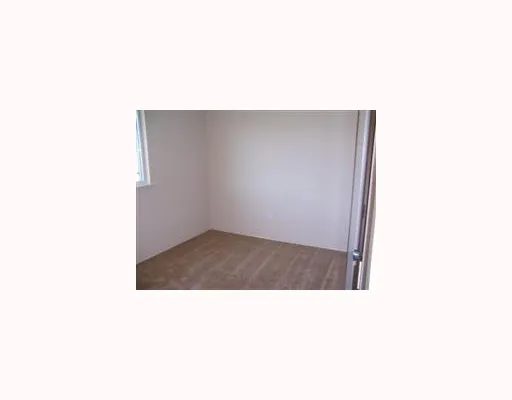 a open kitchen with a white wall and a large window