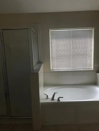 a bathroom with a bathtub and a window