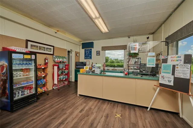 a living room with stainless steel appliances wooden floor and large window