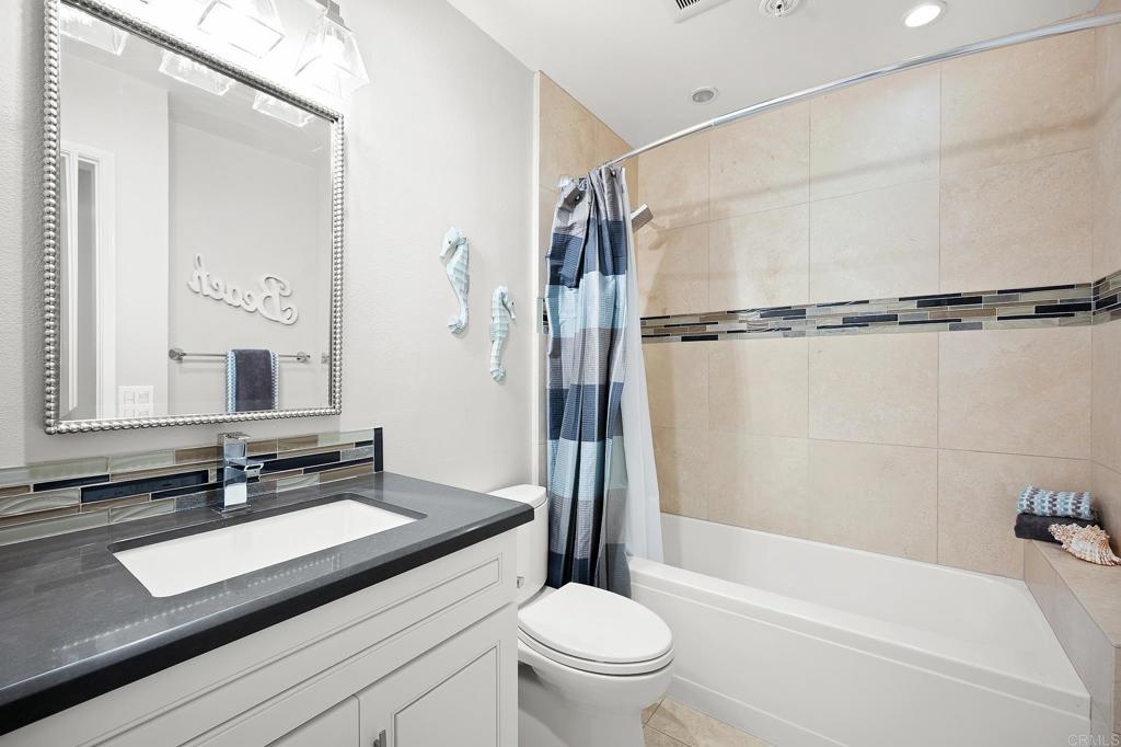 111 Sequoia Avenue, Unit C Carlsbad, CA 92008 - Photo 25 of 38 a bathroom with a sink a toilet a mirror and a bathtub