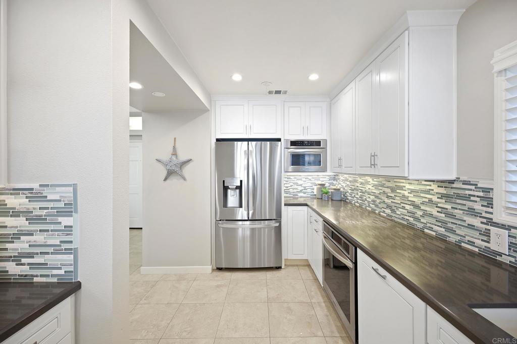 111 Sequoia Avenue, Unit C Carlsbad, CA 92008 - Photo 8 of 38 a kitchen with stainless steel appliances granite countertop a refrigerator and a stove
