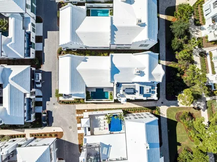 an aerial view of residential houses with outdoor space and parking