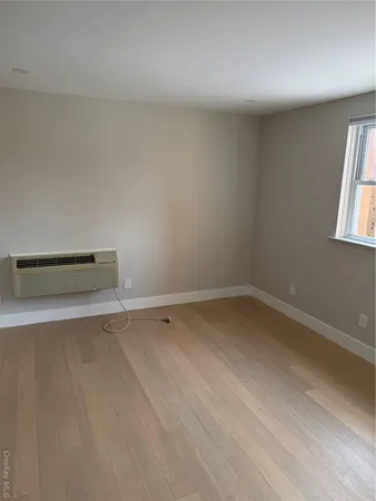 a view of a room with wooden floor and window