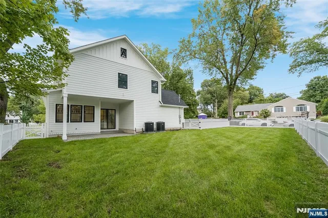 a front view of a house with a garden and trees