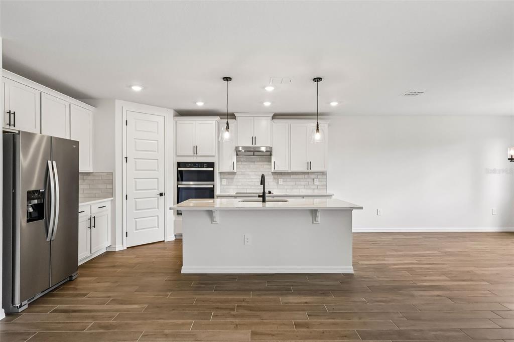 3335 Orchard Loop Bartow, FL 33830 - Photo 12 of 47 a large kitchen with stainless steel appliances a large counter top a stove and a refrigerator