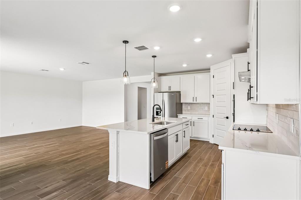 3335 Orchard Loop Bartow, FL 33830 - Photo 13 of 47 a large kitchen with stainless steel appliances kitchen island granite countertop a stove a sink and white cabinets