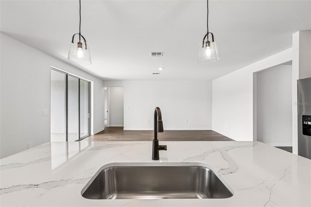 3335 Orchard Loop Bartow, FL 33830 - Photo 14 of 47 a kitchen with a sink and a chandelier