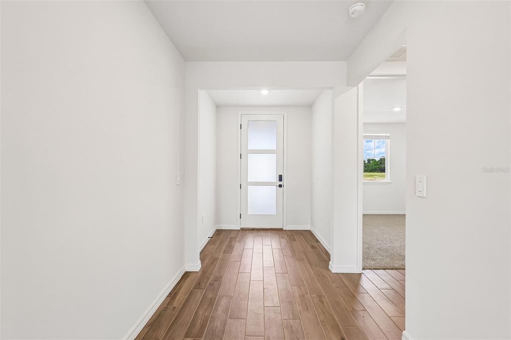 3335 Orchard Loop Bartow, FL 33830 - Photo 5 of 47 a view of a hallway with wooden floor and a bathroom