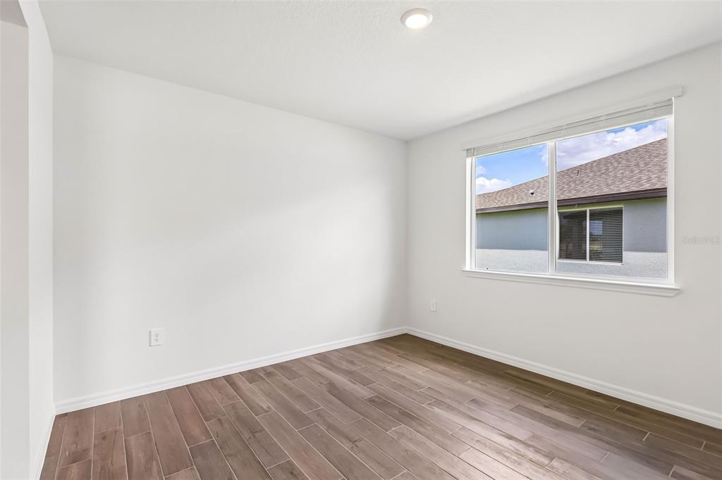 3335 Orchard Loop Bartow, FL 33830 - Photo 6 of 47 a view of an empty room with wooden floor and a window